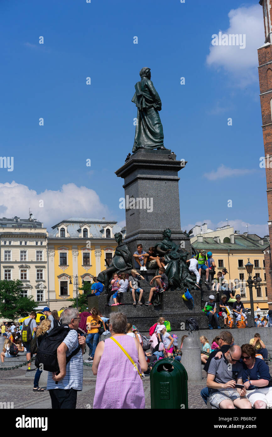 Les enfants polonais assis et reposant sur l'Adam Mikiewicz monument à la place principale,Cracovie,Pologne,l'Europe. Banque D'Images