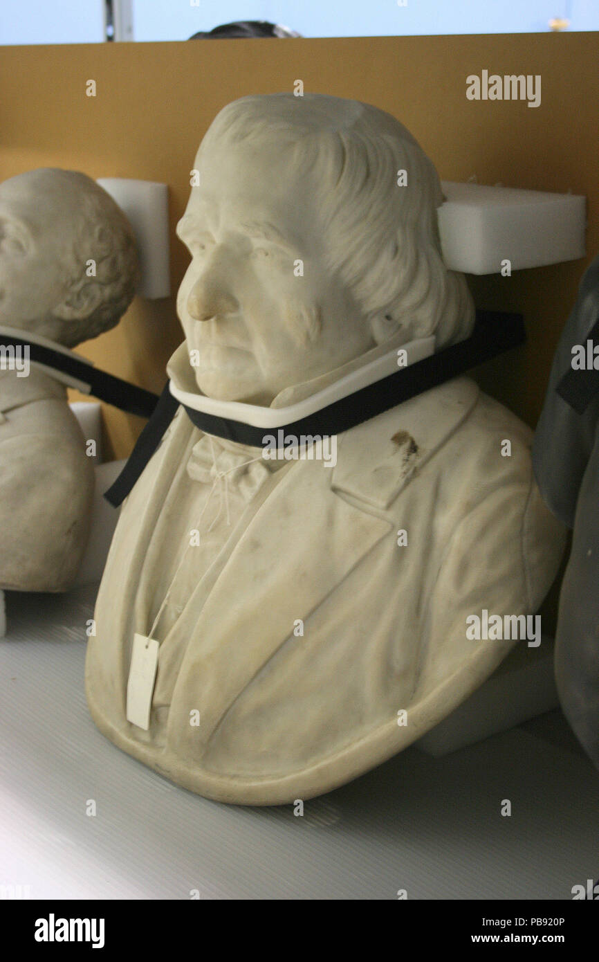 3 personnages en marbre sur un socle avec deux lettres