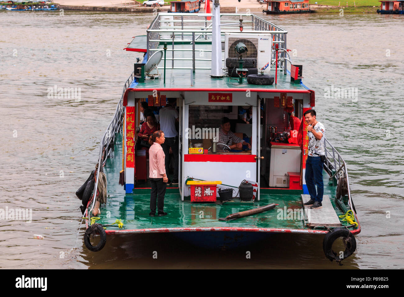 XINGPING, CHINE - 11 MAI 2018 : un bateau de plaisance de touristes quitte l'embarcadère sur la rivière Li connu ainsi que rivière Lijiang qui est en ville de Xinping Banque D'Images