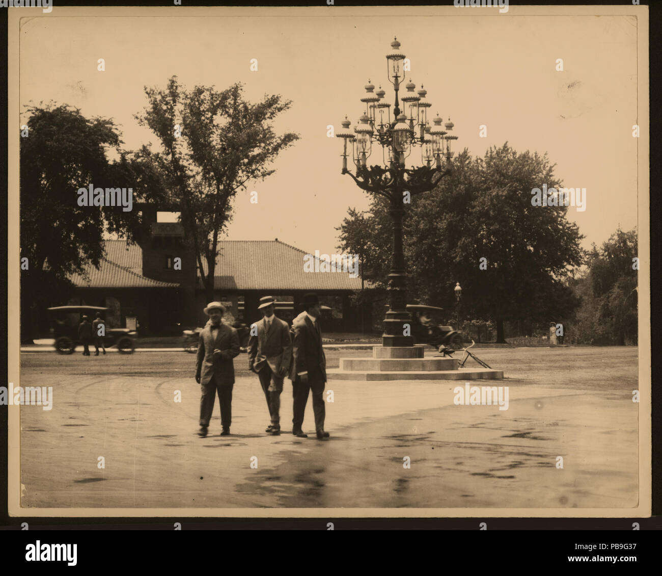 1744 Trois hommes passer une grande lampe à gaz pole devant le chariot, près d'un parc non identifiés Banque D'Images