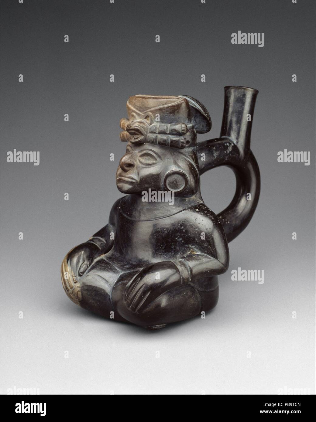 Personnage assis bouteille. Culture : moche. Dimensions : hors tout : 6 3/8 in. (16,19 cm). Date : 2ème-5ème siècle. L'étrier-spout navire--ainsi nommé pour la similitude de la forme de la tuyère à celui d'une selle d'équitation étrier--était une forme de bouteille beaucoup favorisée dans Pérou précolombienne. Il a été suggéré que la particularité de la direction générale de la double/simple-spout forme était d'empêcher l'évaporation des liquides qu'il contient. La tuyère d'étrier a été utilisé sur les navires en céramique dans le nord du Pérou pendant environ vingt-cinq cents ans. Au début du premier millénaire avant J.-C., l'étrier-spout bouteille a été élaboré en œuvre sculpturale de Banque D'Images