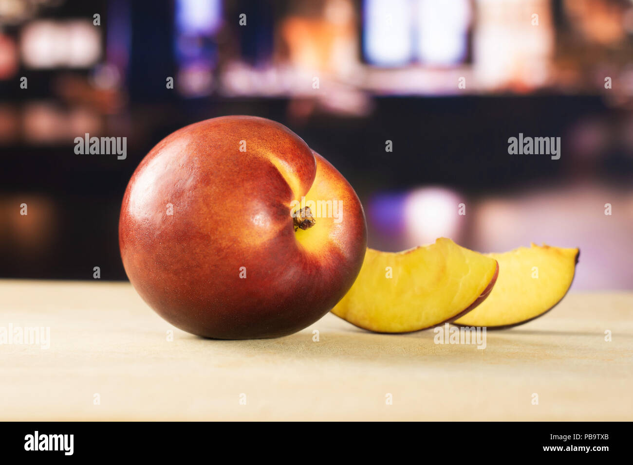Groupe d'un ensemble de deux tranches de nectarine mûre rouge profond avec restaurant en arrière-plan Banque D'Images
