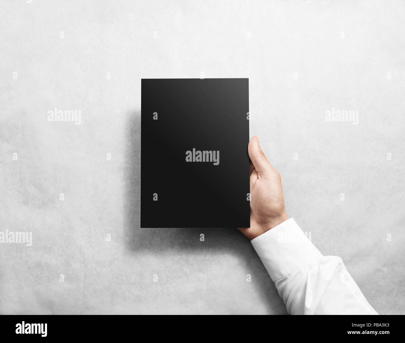 Hand holding blank black brochure brochure immersive. Notice de présentation des maquettes. Brochure tenir la main. Man show livre papier offset. Modèle de fiche. Bookle Banque D'Images