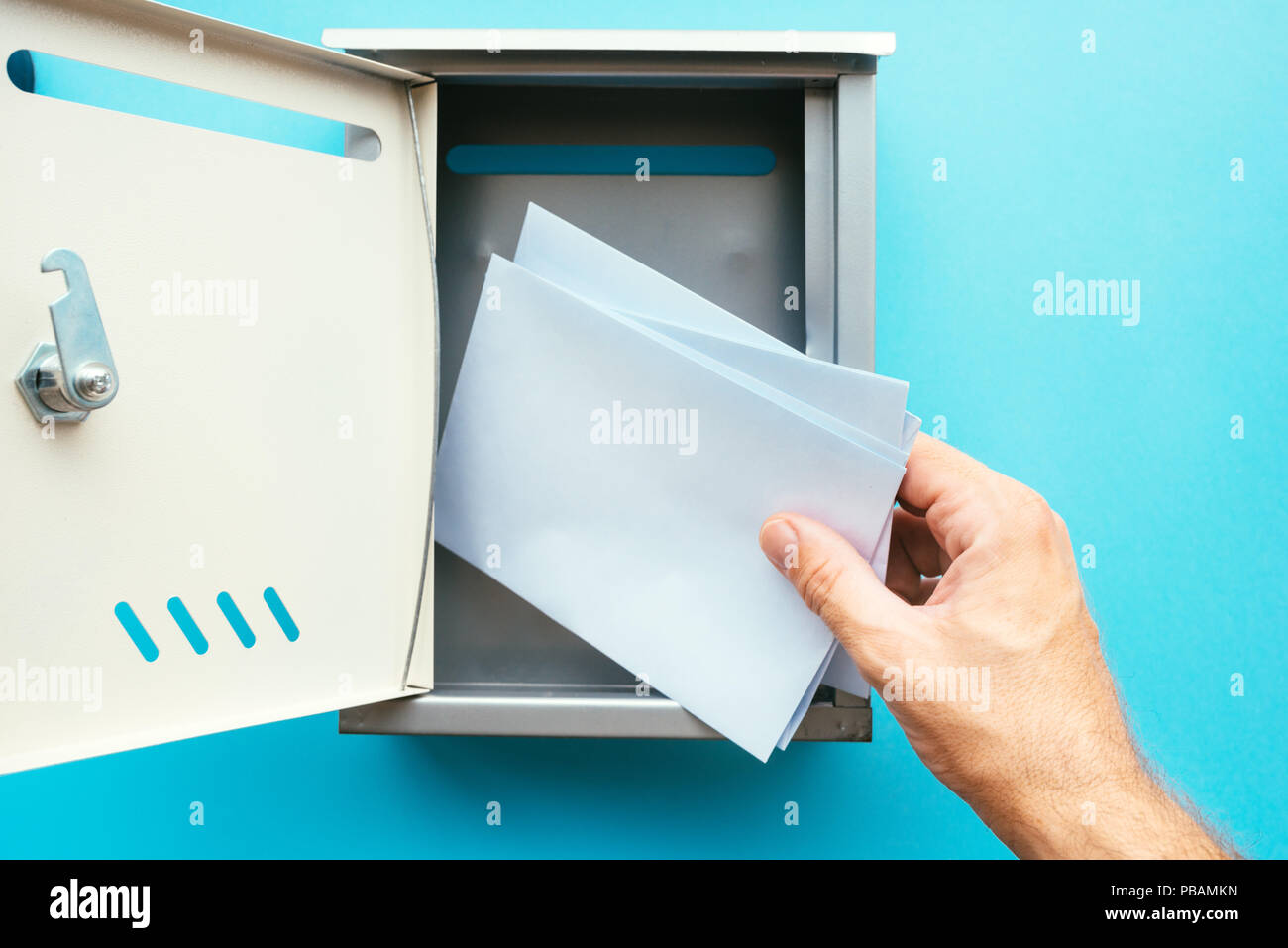 Hand inserting lettre enveloppe dans la boîte aux lettres, des maquettes pour la communication et l'image thèmes correspondance Banque D'Images