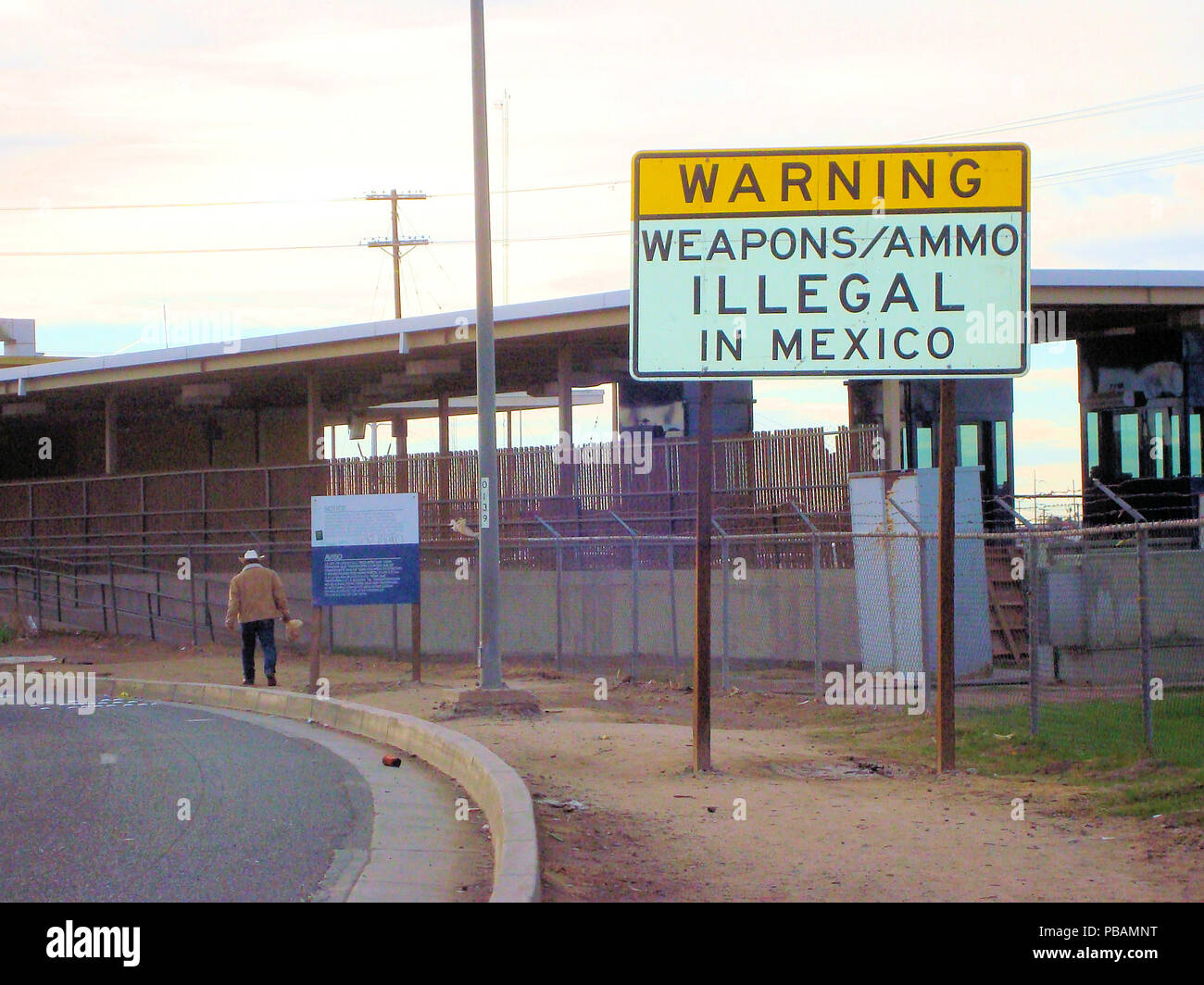 Les voyageurs d'avertissement signe que les armes, les munitions sont illégales au Mexique ; l'homme marcher au Mexique. Poste frontalier de Calexico, en Californie, aux États-Unis. Banque D'Images
