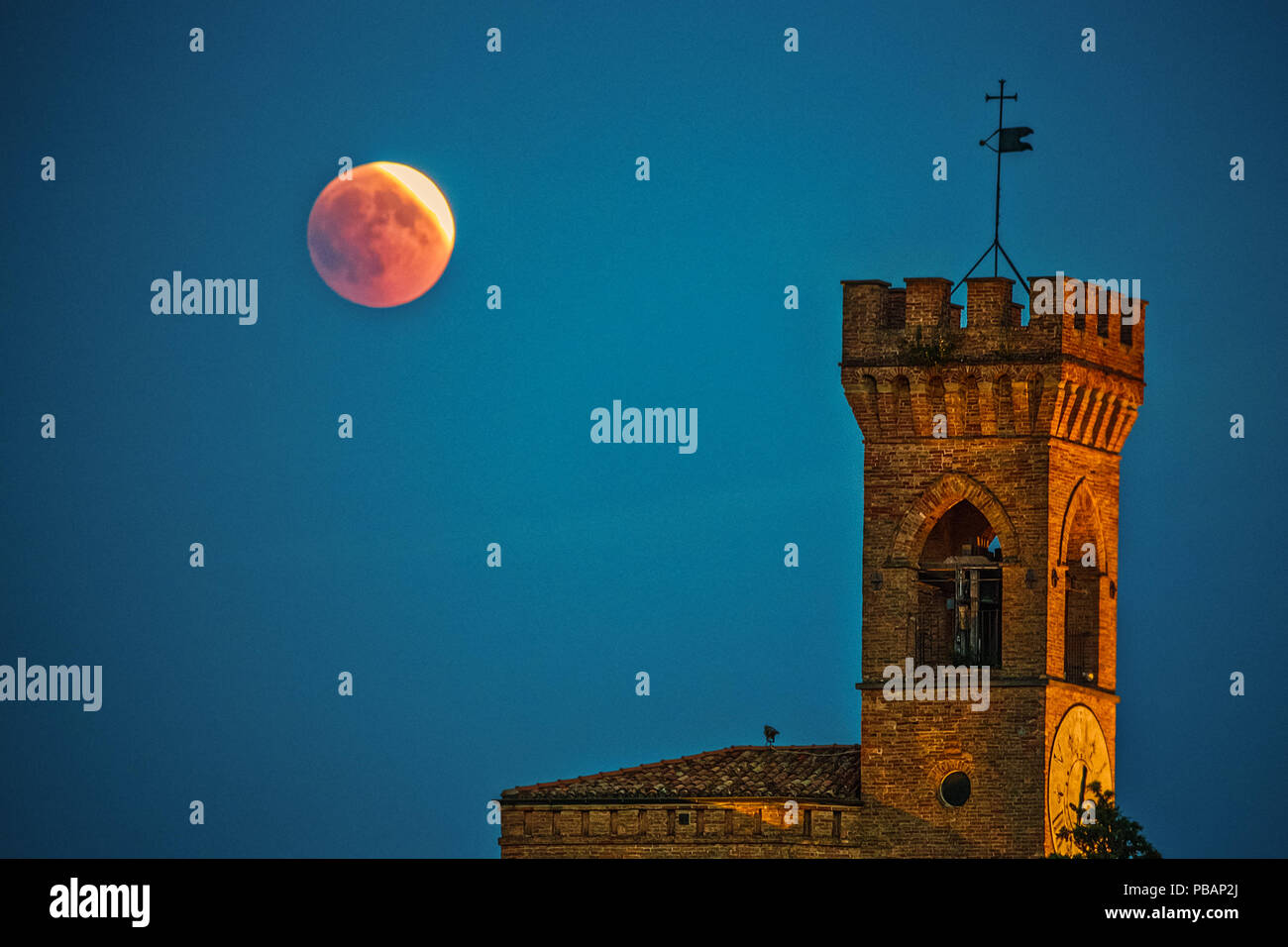 Eclipse de Lune rouge sur la tour de l'horloge en Italie Banque D'Images