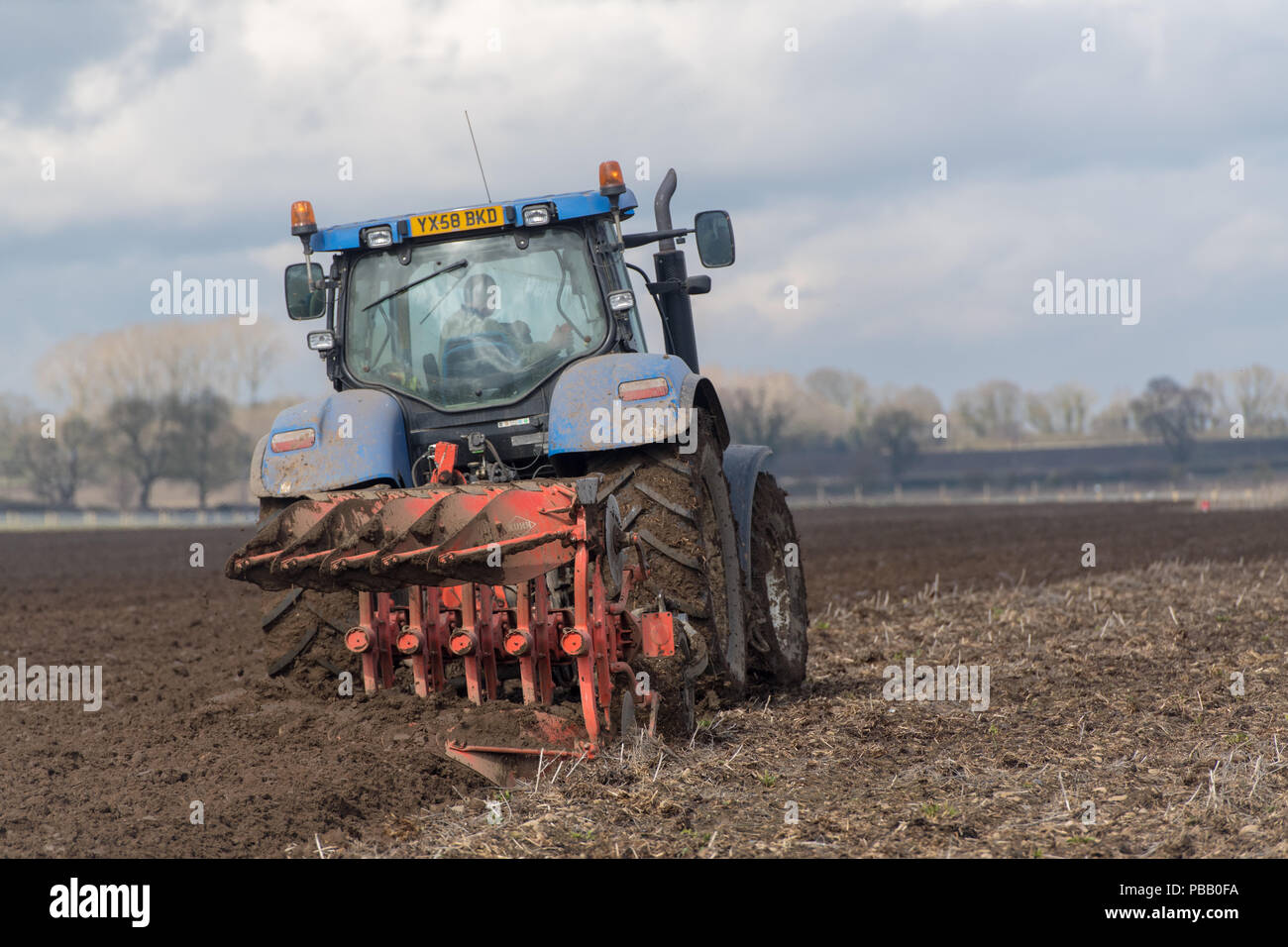 Labourer un champ avec un New Holland T7030 et d'un sillon de charrue Kuhn 5 réversible, la position de l'établissement. North Yorkshire, UK. Banque D'Images