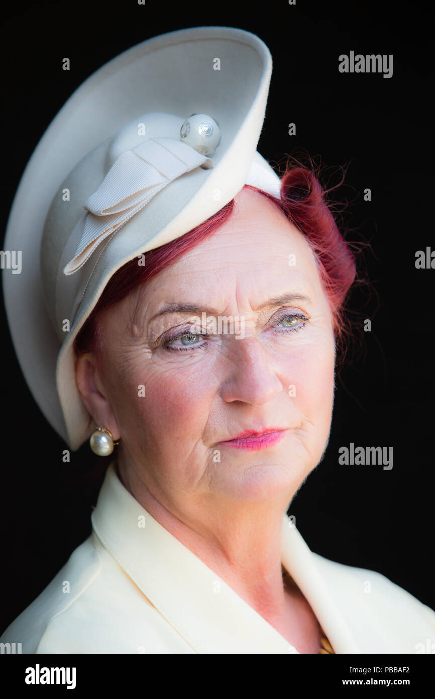 Détaillé, close-up portrait : femme de la reconstitution médiévale, intelligemment habillés avec de grands posh hat, Black Country Museum 1940 événement. Fond noir. Banque D'Images