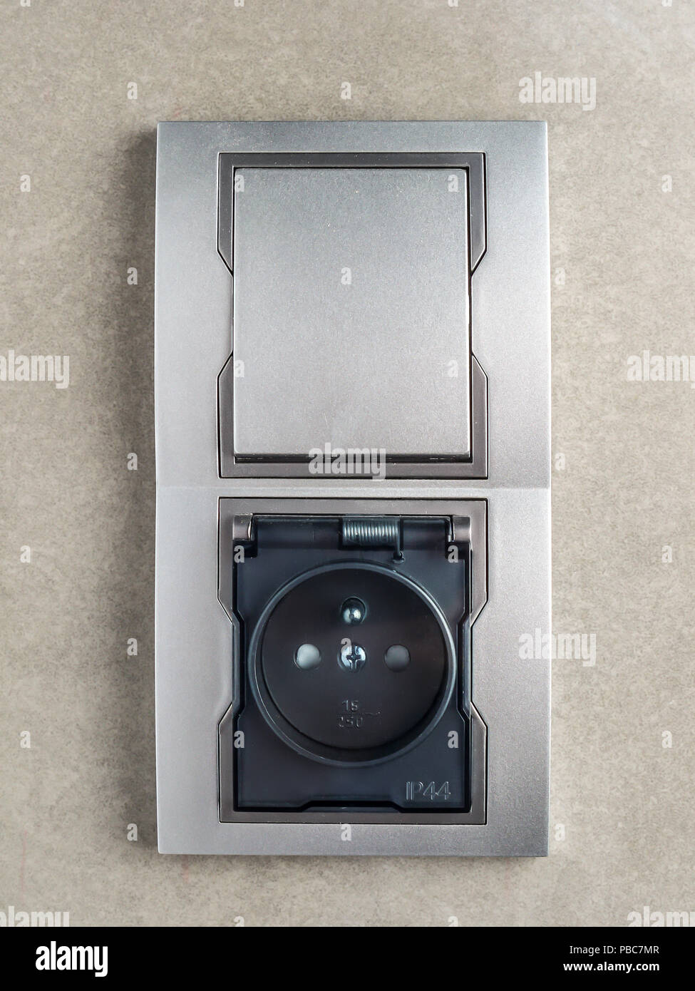 Salle de bains intégrée prise murale et branchez-le sur le mur carrelé gris Banque D'Images