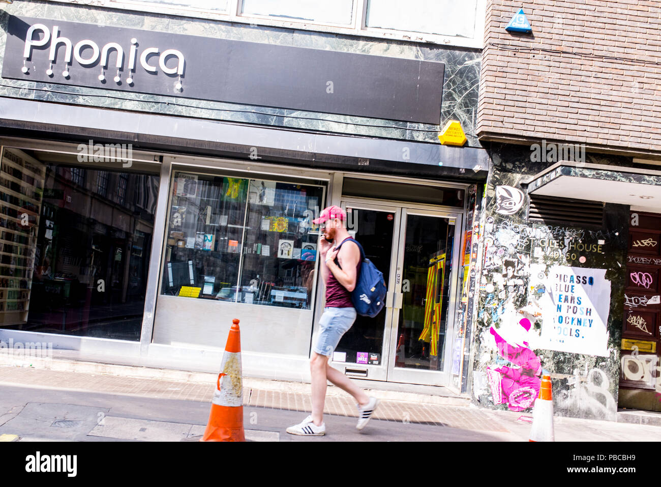Homme marchant dans la rue en face de la Pologne Phonica, un vinyl boutique au coeur de Soho, London, UK Banque D'Images