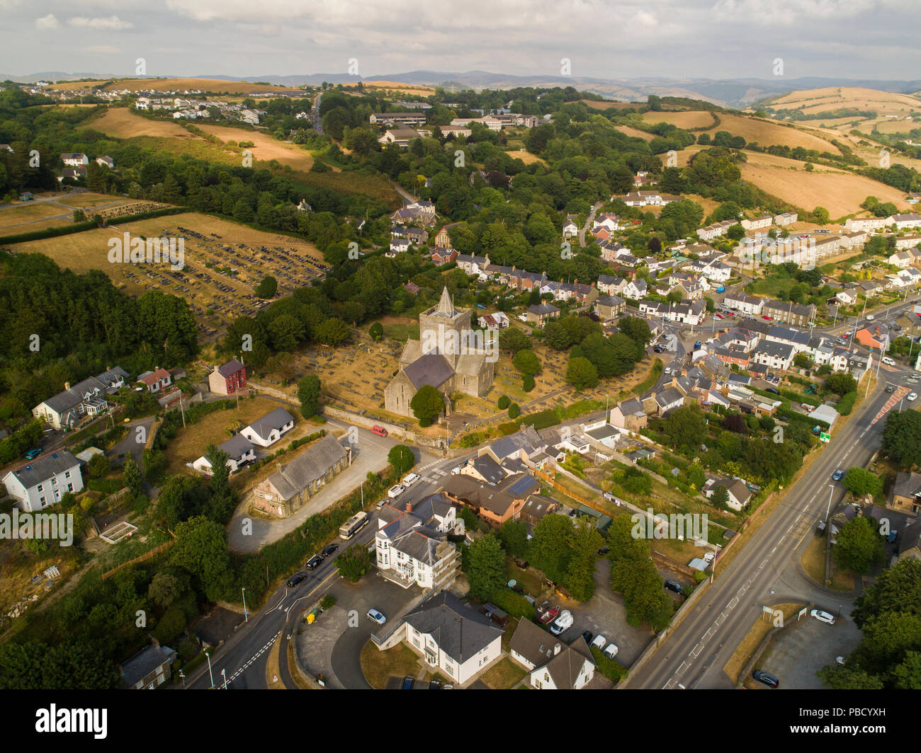 Drone aérien vue de l'église St Padarn médiévale dans le centre du village de Llanbadarn Fawr à la périphérie d''Aberystwyth, Ceredigion, pays de Galles, Royaume-Uni. L'été 2018, montrant la région aride champs sec résultant de la sécheresse de l'été Banque D'Images