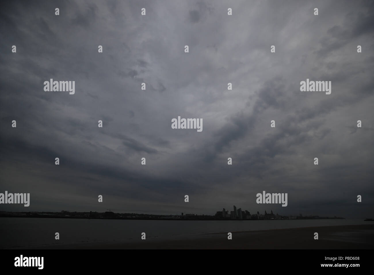 Nuages sur Liverpool Waterfront masque une vue de la "Lune de sang", la plus longue éclipse lunaire du siècle qui voit le satellite naturel de la Terre tourner rouge sang. Banque D'Images
