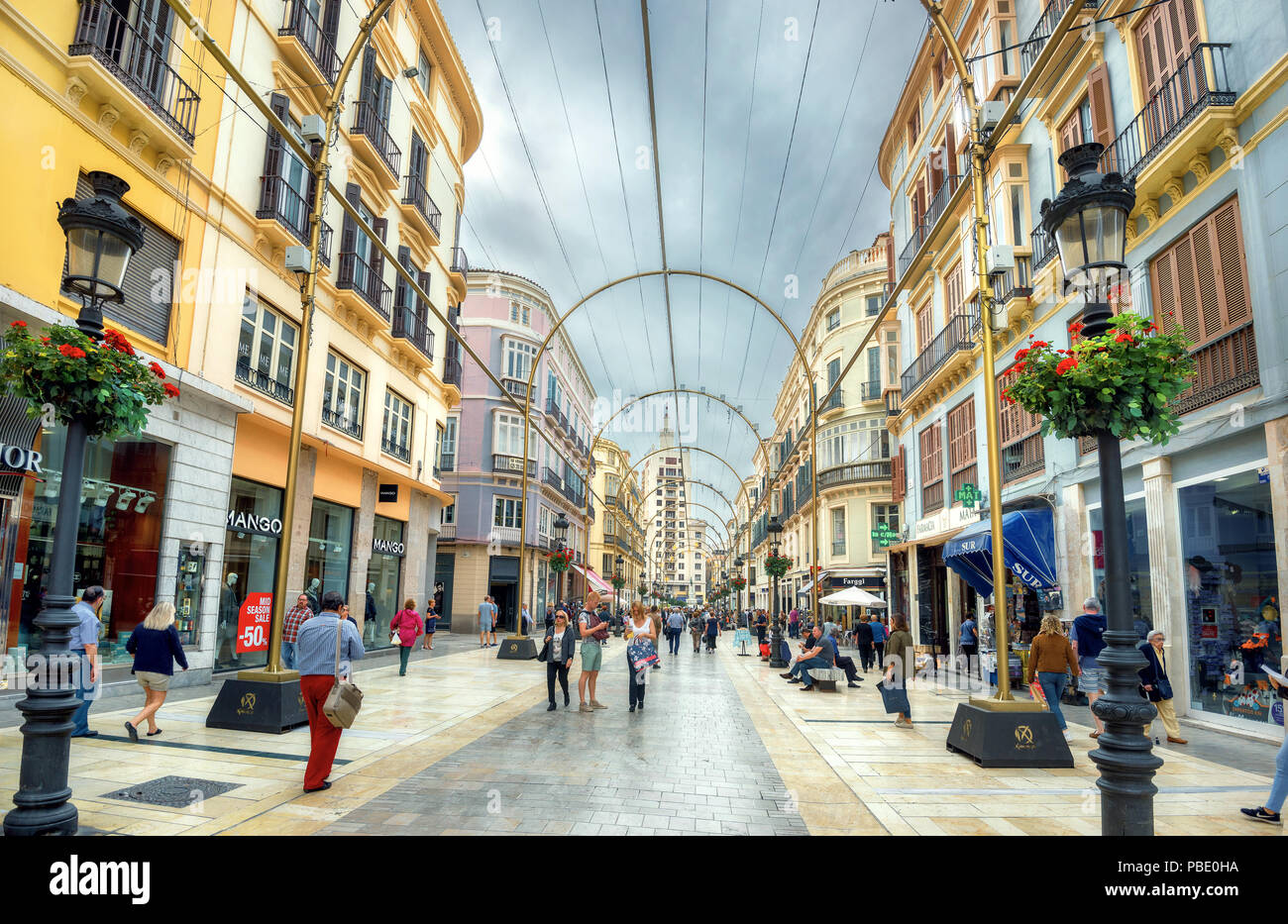 Avis de marques de Larios rue principale avec des boutiques, un café et quelques personnes dans le centre-ville commercial. Malaga, Espagne Banque D'Images