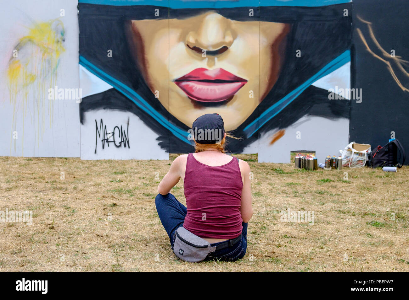Bristol, Royaume-Uni. 28 juillet, 2018. L'artiste connu comme Mazcan est représenté à la rue South Park, Bedminster comme elle s'assoit pour voir ses progrès comme elle commence à créer ses œuvres pour le festival. Upfest est le plus important d'Europe gratuitement, street art & graffiti festival et est maintenant dans sa dixième année. Credit : Lynchpics/Alamy Live News Banque D'Images