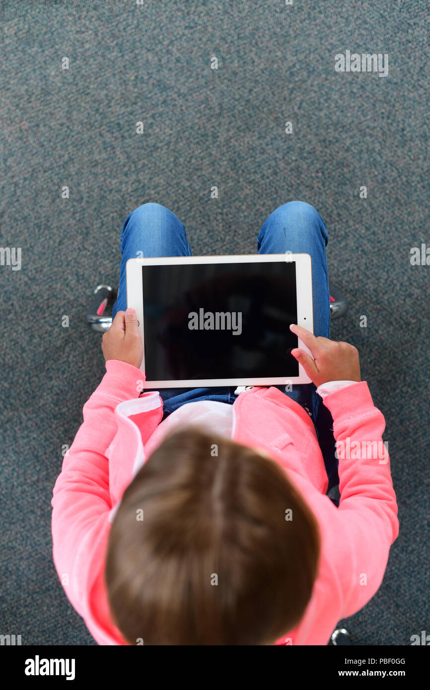 Fille 9 10 11 sur un ipad avec un écran blanc copie espace d'âge de l'école élémentaire Banque D'Images