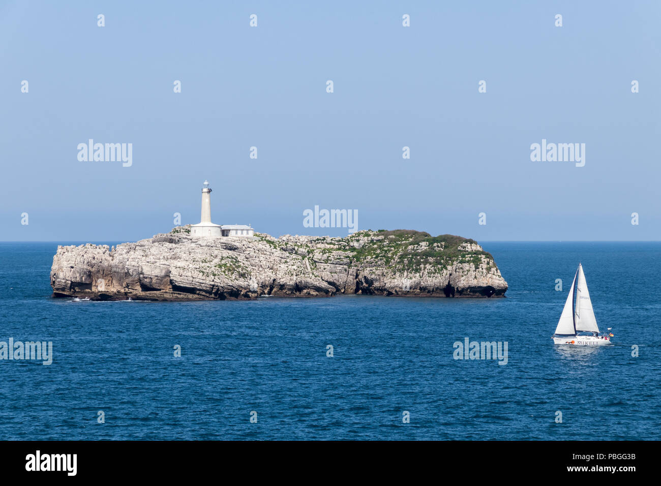 Santander, Espagne. Opinions de l'Isla de Mouro (Mouro Island) de la péninsule de la Magdalena, en Cantabrie, avec un petit voilier au premier plan Banque D'Images