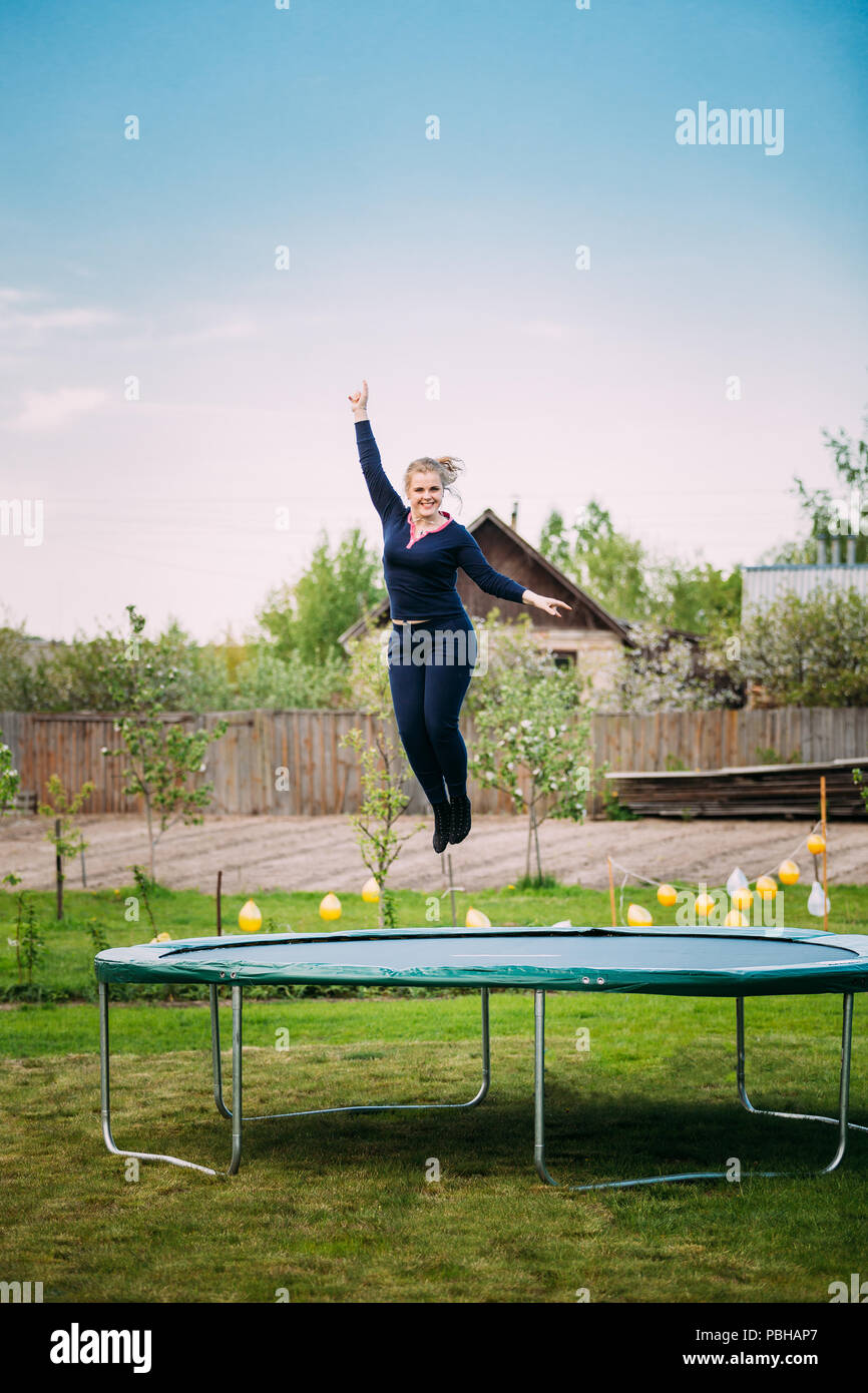 Les jeunes Caucasiens blancs belle grande taille femme fille sautant sur le  trampoline en été jour nuageux Photo Stock - Alamy