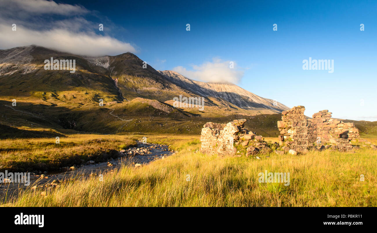 Un ruisseau de montagne s'écoule les pentes de montagne Beinn Eighe et passé les ruines d'un petit immeuble à Glen Torridon dans la région des collines de Torridon t Banque D'Images
