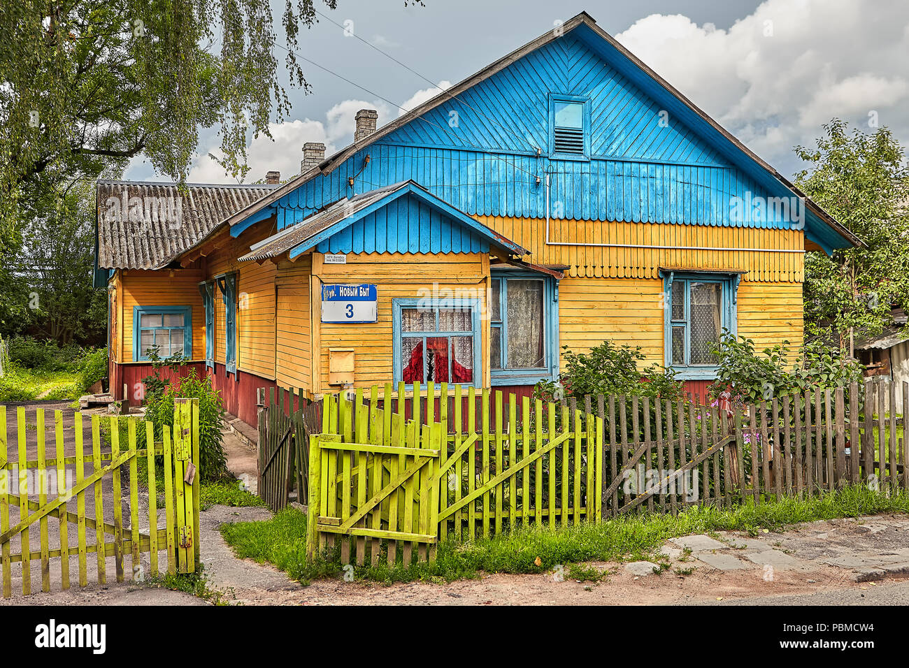 Minsk, Belarus - Juillet 7, 2018 : ancienne maison en bois avec toit bleu, entouré d'une clôture, se dresse dans le village de Biélorussie. Banque D'Images