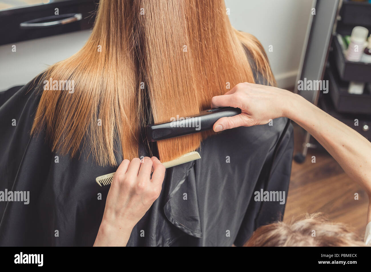 Au lissage des cheveux de beauté. Coiffure coiffure pour un client avec un sèche  cheveux fer Photo Stock - Alamy