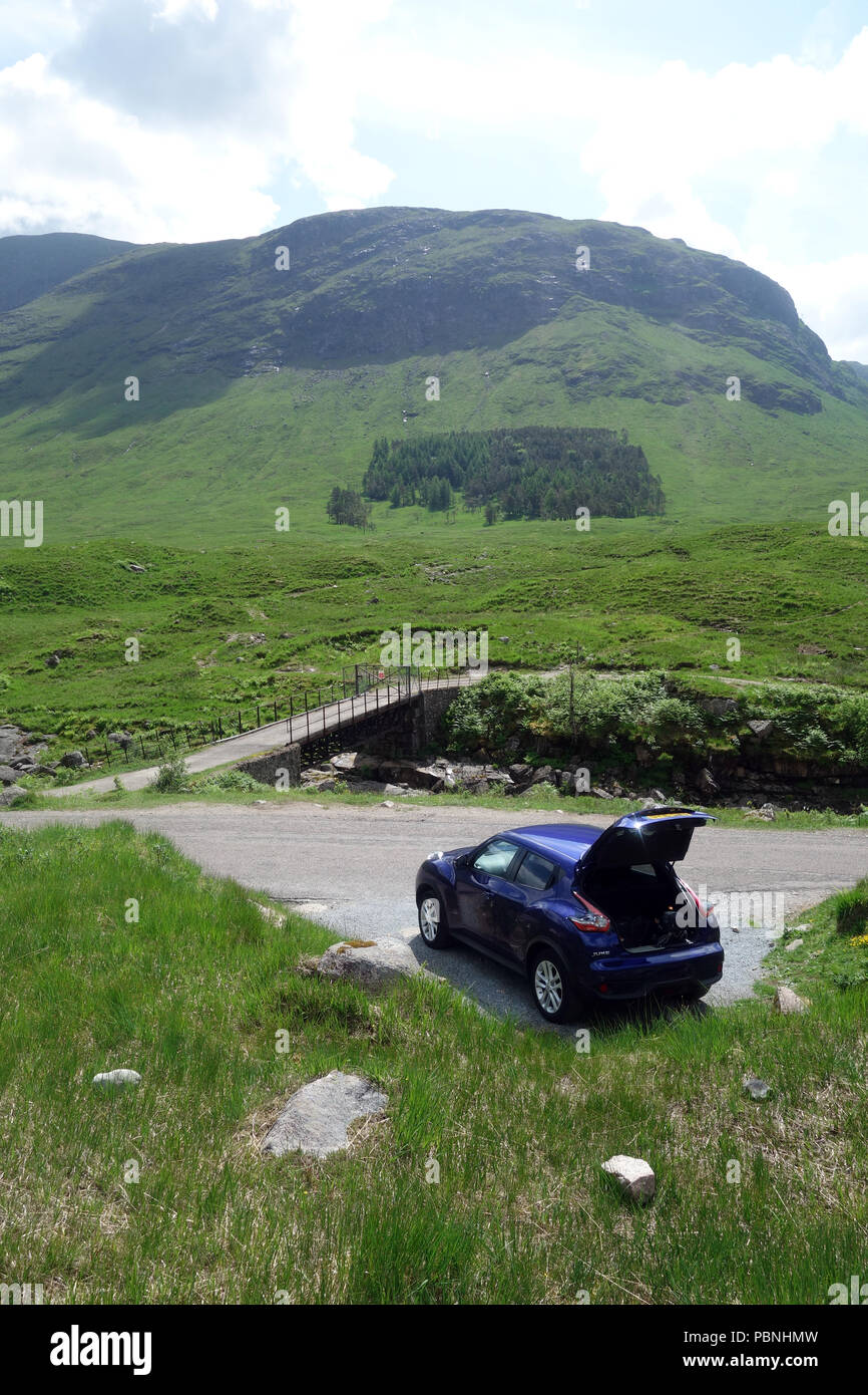 Nissan Juke bleu parqué dans une aire sous la montagne écossais Beinn Corbett Mhic Chasgaig dans Glen Etive, Highlands, Ecosse, Royaume-Uni. Banque D'Images