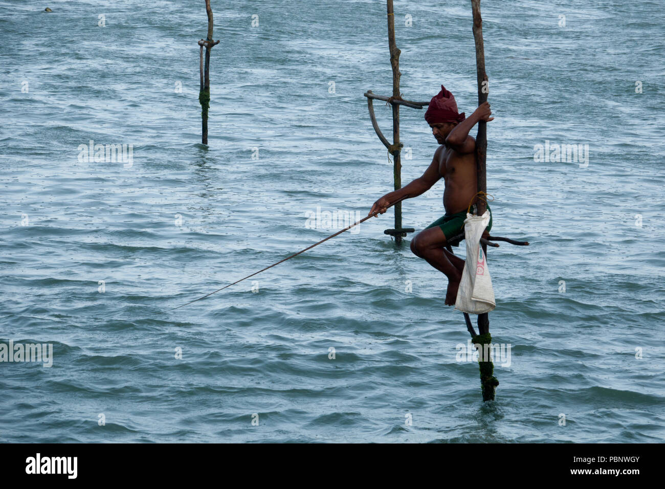 Pêcheur sur pilotis du Sri Lanka à la pêche tôt le matin Ahangama beach Banque D'Images