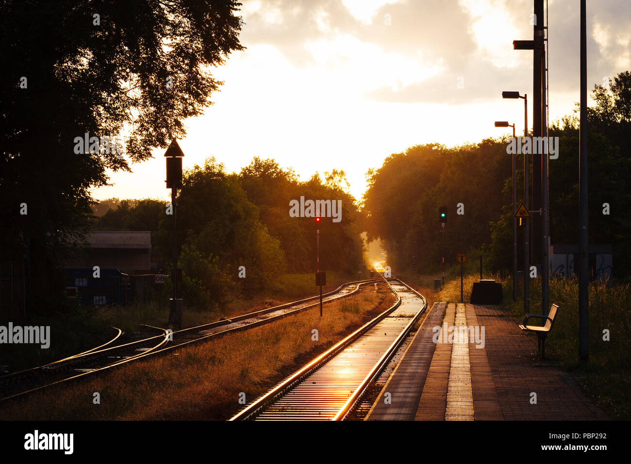 La fin de l'après-midi du soleil se reflète sur les rails à côté de la plate-forme à la petite gare de Quelle, près de Halle (Westfalen), Allemagne. Banque D'Images