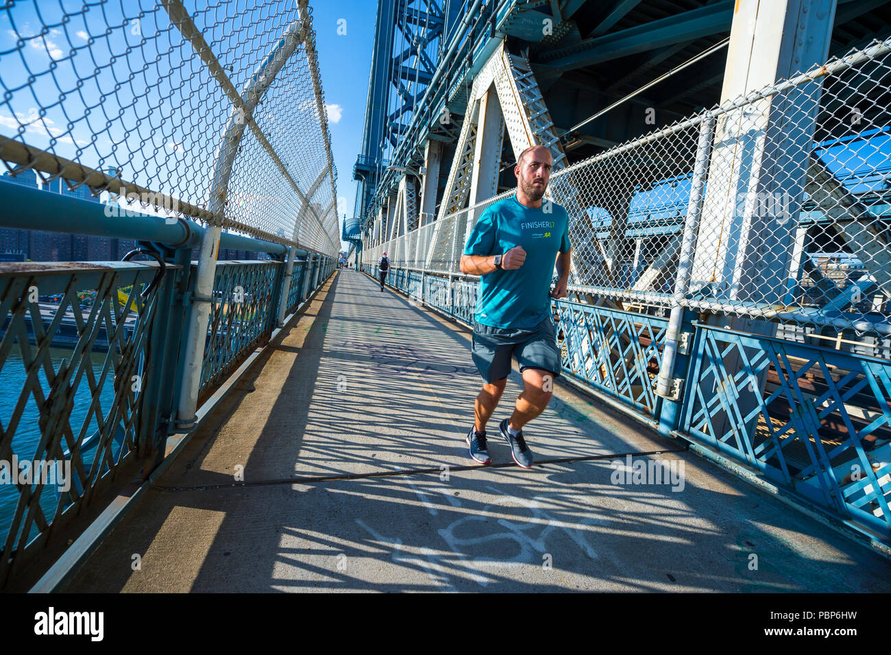 NEW YORK - circa 2017, août : Jogger traverse le pont de Manhattan. Banque D'Images