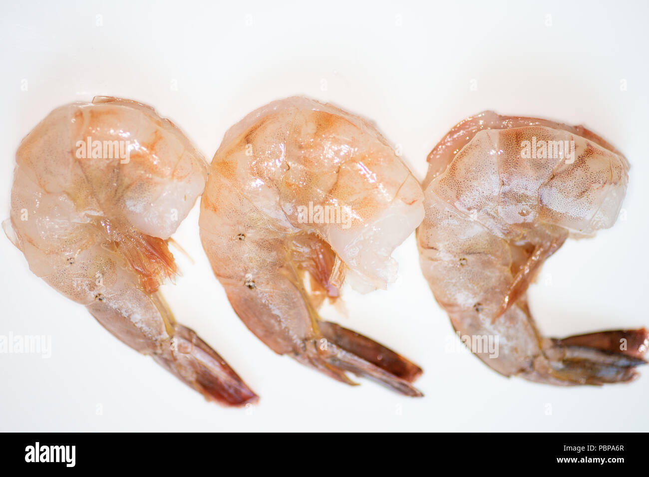 Trois crevettes frais lavés et rincés seulement préparés à être cuite.sur le comptoir de la cuisine. Banque D'Images