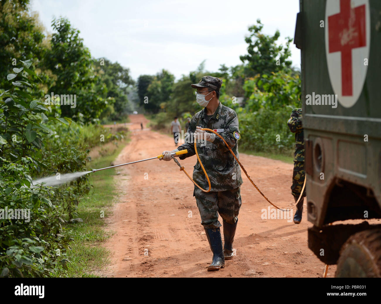 (180729) -- SANAMXAY (Laos), le 29 juillet 2018 (Xinhua) -- un membre de l'Armée de libération du peuple chinois (PLA) Peace Train sprays désinfectant dans l'équipe médicale d'Sanamxay Mitsamphan village, district Province Attapeu, le Laos, le 29 juillet 2018. Un PLA contingent médical a commencé à travailler sur la maîtrise de l'épidémie dans les refuges pour les victimes après une rupture de barrage de crues éclair déclenchée dans le sud de la province d'Attapeu au Laos, le contingent a déclaré vendredi en fin. (Xinhua/Liu Ailun) Banque D'Images