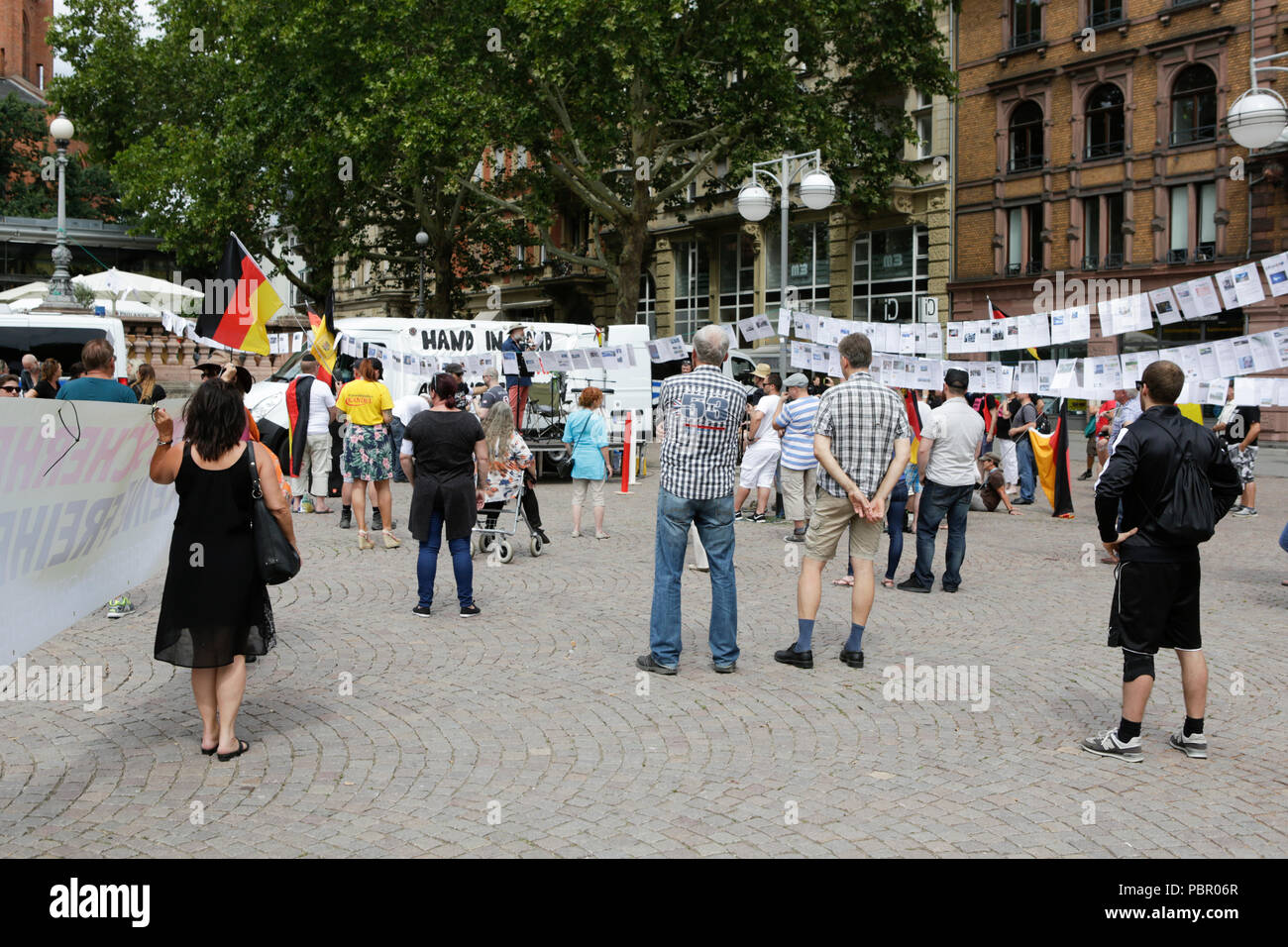 Wiesbaden, Allemagne. 29 juillet 2018. Les manifestants de droite écouter les discours. Les manifestants de droite de la main dans la main - Gegen die Gewalt auf unseren Strasen (Main dans la main - contre la violence dans nos rues) Le mouvement a tenu un rassemblement anti-gouvernement à Wiesbaden. Cette protestation a eu lieu sous le prétexte d'un vigile pour l'adolescent Susanna F, qui aurait été tué par un réfugié à Wiesbaden. Le rallye a été abordée par plusieurs orateurs anti-gouvernement, qui a demandé la démission du gouvernement. Banque D'Images