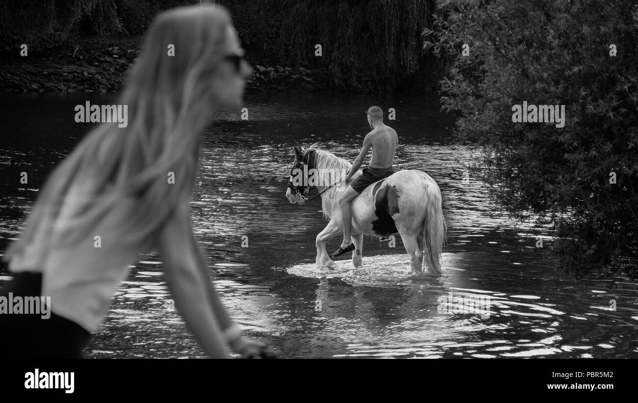 Going for a Ride. Un cycliste passe un cheval-cavalier dans une rivière le long de la Tamise à Londres Banque D'Images