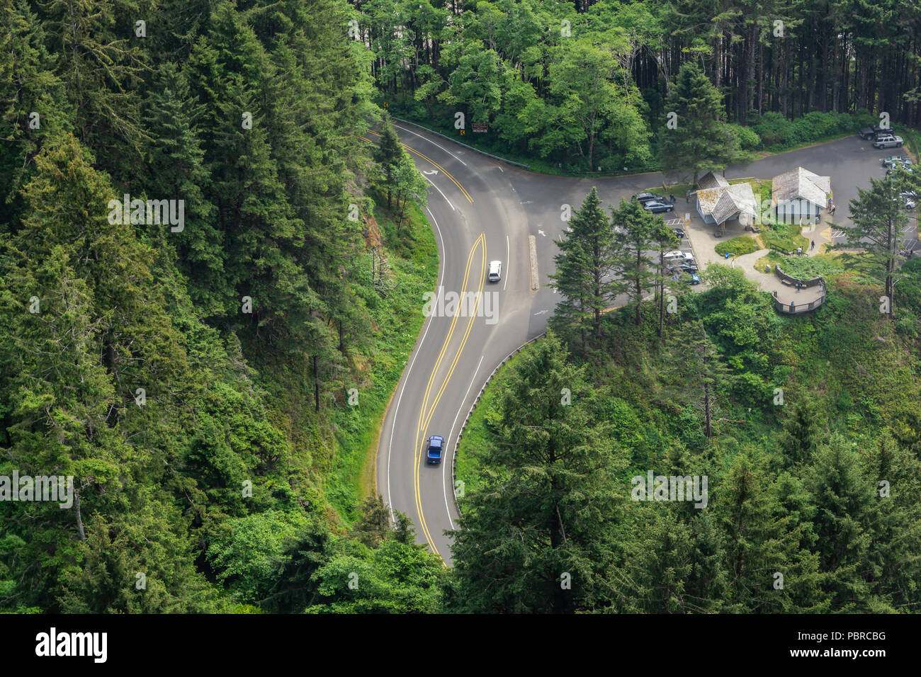 Vue aérienne de la route US 101 at Cape Perpetua Scenic Area avec aire de repos et de trafic, serpentant à travers la forêt de pins, Oregon, USA. Banque D'Images