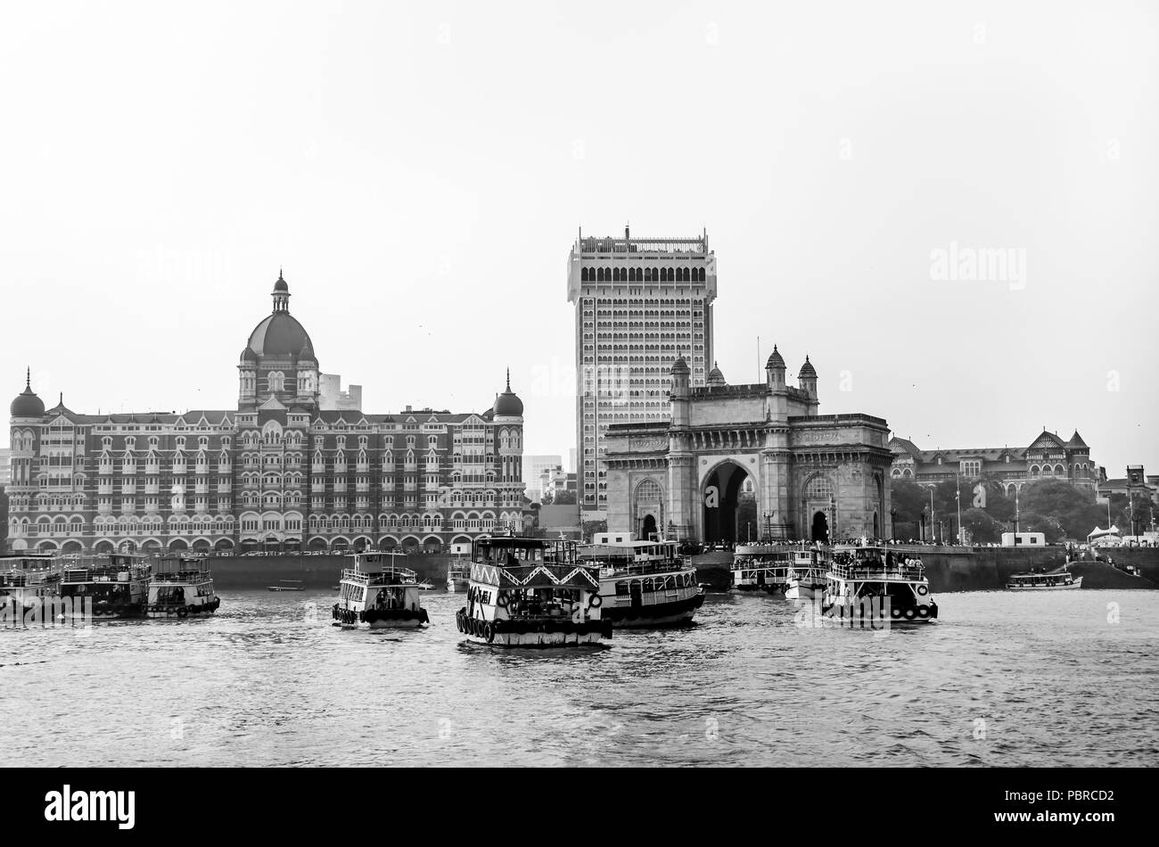 La porte de l'Inde et de bateaux dans l'arrière-plan Taj Hotels, Mumbai, Inde. Elle a été érigée pour commémorer le débarquement du roi George V et la reine Mary. Banque D'Images
