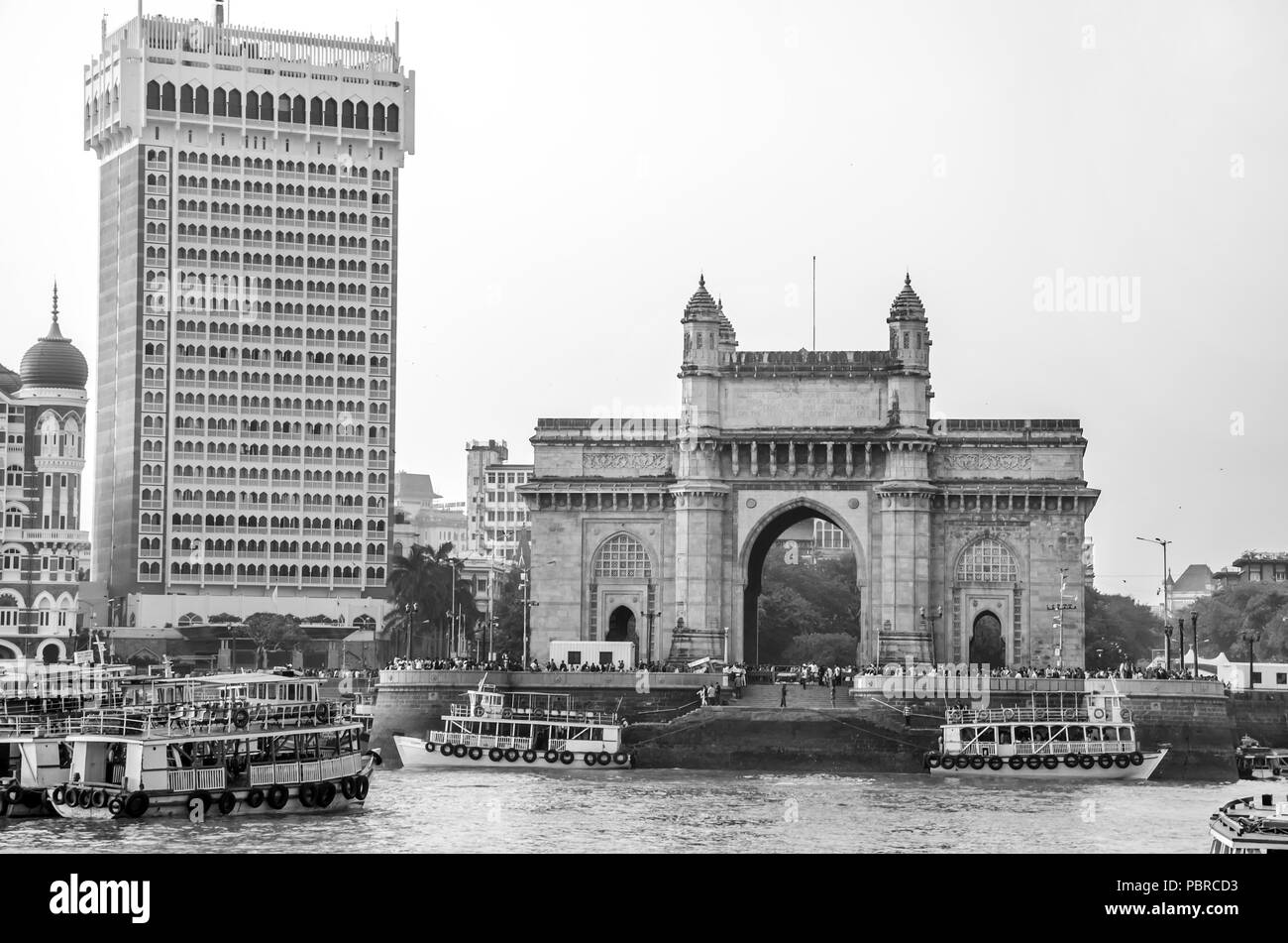 La porte de l'Inde et de bateaux dans l'arrière-plan Taj Hotels, Mumbai, Inde. Elle a été érigée pour commémorer le débarquement du roi George V et la reine Mary. Banque D'Images