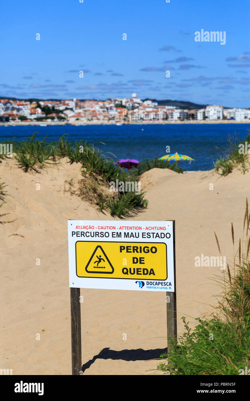 Signer en portugais sur la plage de Sao Martinho do Porto indiquant que le chemin est en mauvais état et il y a un danger de chute. Banque D'Images