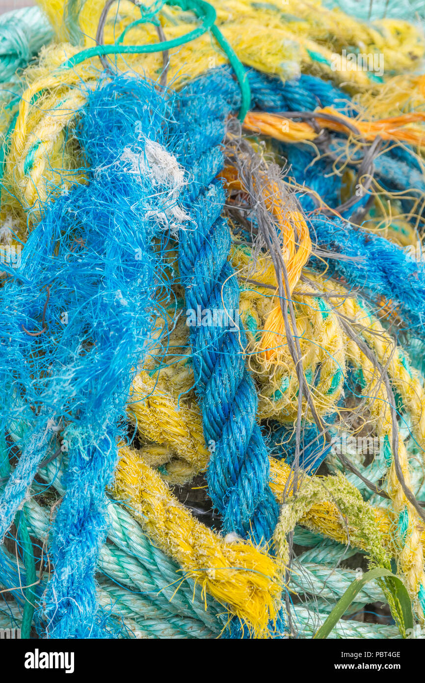Pile colorée de cordes en plastique anciennes et effilochées et de filets utilisés pour la pêche. Corde de tir de gros plan. Banque D'Images