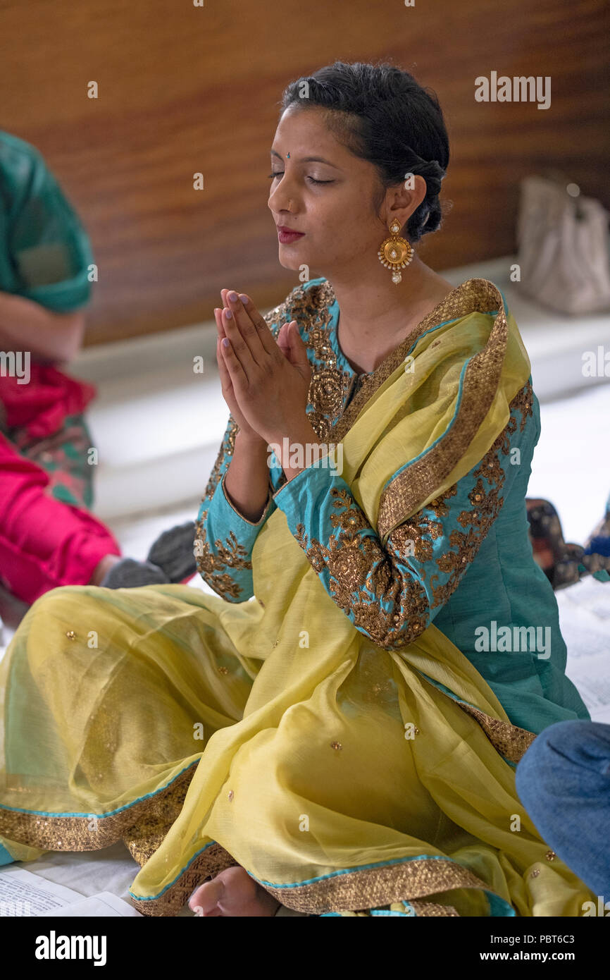 Une belle femme hindoue dans la prière et méditation au Milan Mandir temple hindou de South Ozone Park, Queens, New York. Banque D'Images