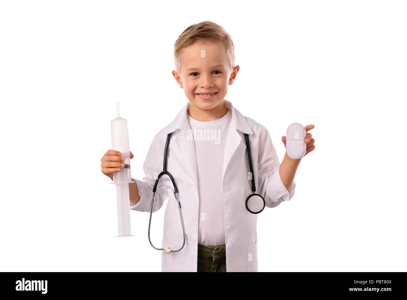 Un petit garçon souriant, médecin en uniforme médical, isolé sur blanc, avec stéthoscope sur le cou, vous rappelle au sujet des soins de santé. Banque D'Images