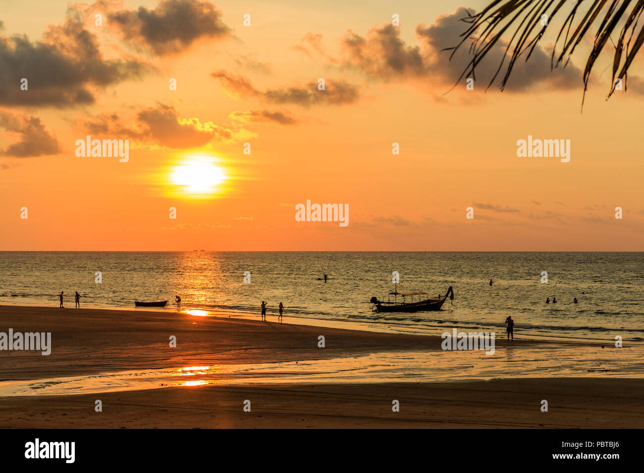 Les gens qui se découpent sur la plage au coucher du soleil, Kamala, Phuket, Thailand Banque D'Images