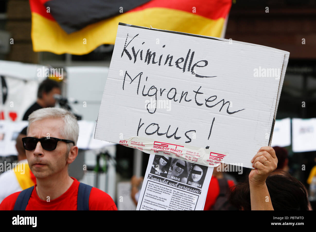 Wiesbaden, Allemagne. 29 juillet, 2018. Un manifestant de l'aile droite est titulaire d'un signe qui se lit "migrants criminels out !". Les manifestants de droite de la main dans la main - Gegen die Gewalt auf unseren Strasen (Main dans la main - contre la violence dans nos rues) Le mouvement a tenu un rassemblement anti-gouvernement à Wiesbaden. Cette protestation a eu lieu sous le prétexte d'un vigile pour l'adolescent Susanna F, qui aurait été tué par un réfugié à Wiesbaden. Le rallye a été abordée par plusieurs orateurs anti-gouvernement, qui a demandé la démission du gouvernement. Crédit : Michael Debets/Pacific Press/Alamy Live News Banque D'Images