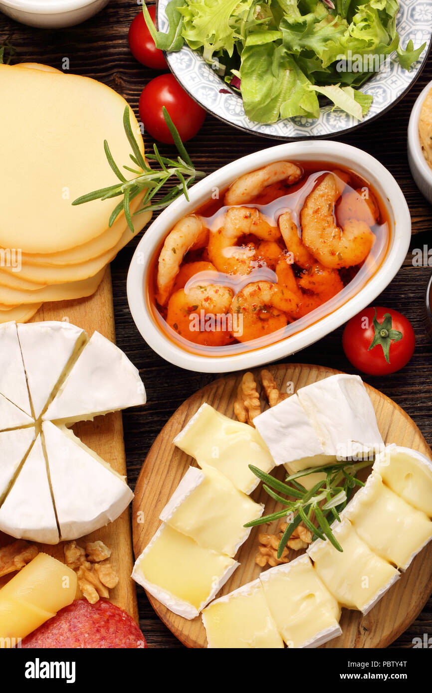 Crevettes et fromage apéritif situé sur la planche de bois rustique Banque D'Images