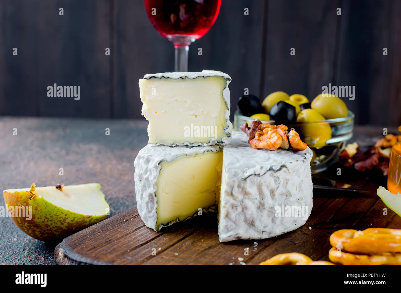 Tranches de fromage, fromage par la rouille, fromage à pâte dure, les olives, les noix, les arachides, le miel, un verre de vin, un dîner romantique, un repas pour les shurman Banque D'Images