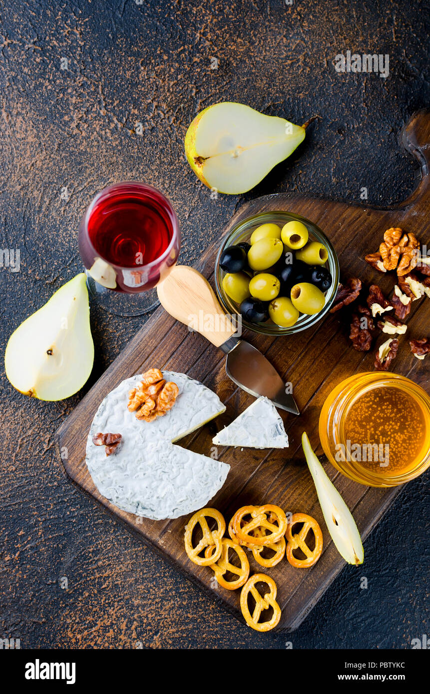 Tranches de fromage, fromage par la rouille, fromage à pâte dure, les olives, les noix, les arachides, le miel, un verre de vin, un dîner romantique, un repas pour les shurman Banque D'Images