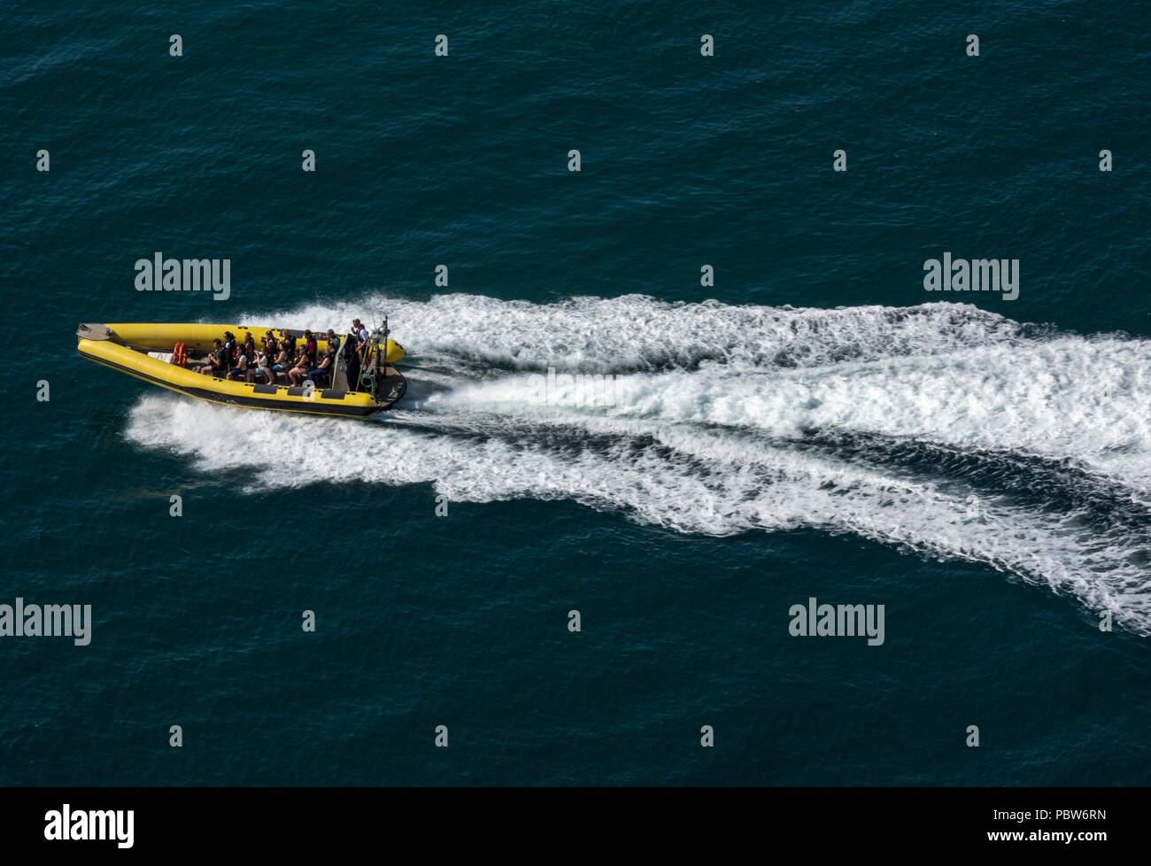 Une grande vitesse de course de bateaux rib rapide sur l'eau plein de passagers causant des vagues et service. Banque D'Images
