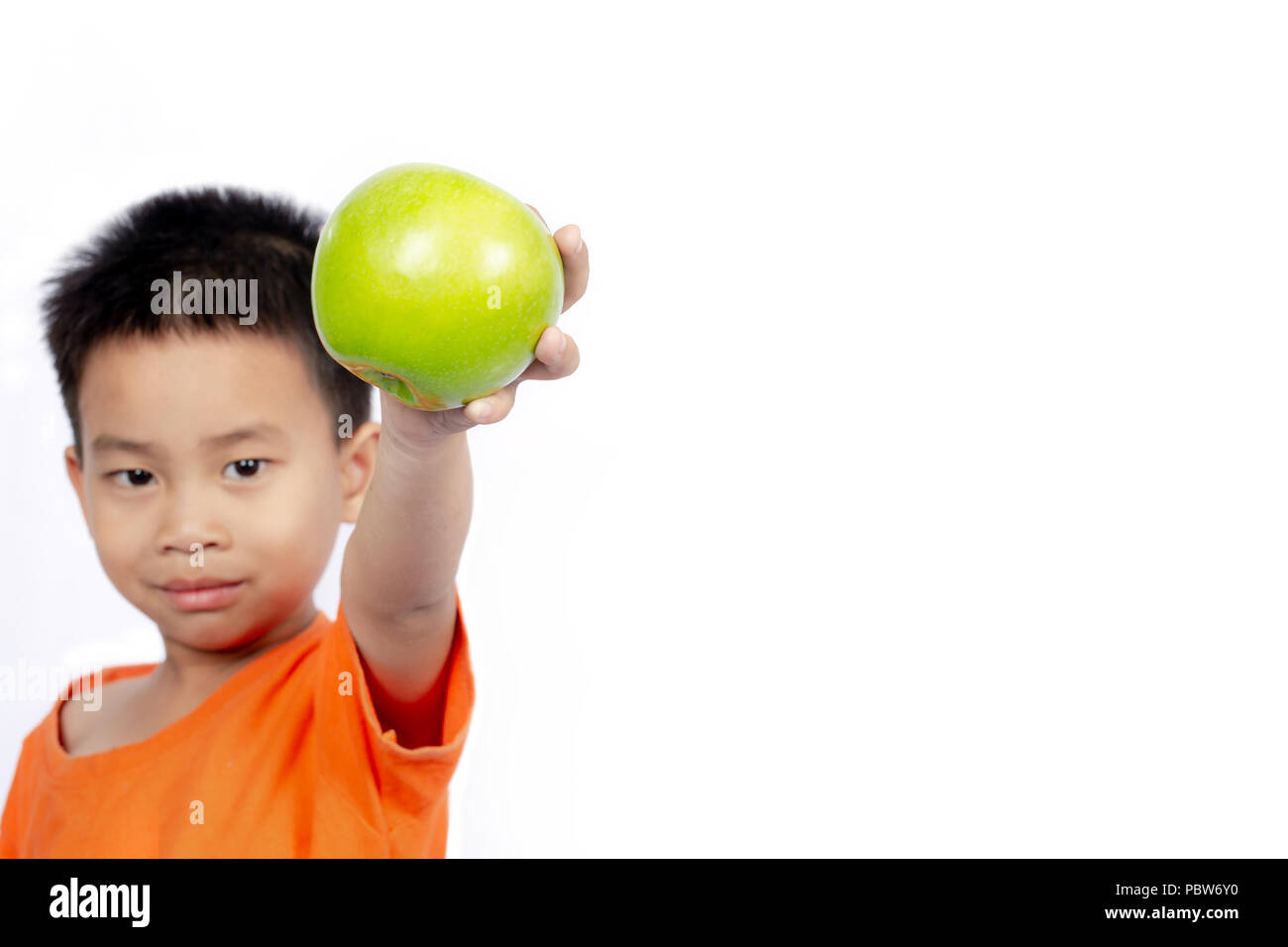 En attente de l'enfant tenue orange pomme verte sur fond blanc. Banque D'Images