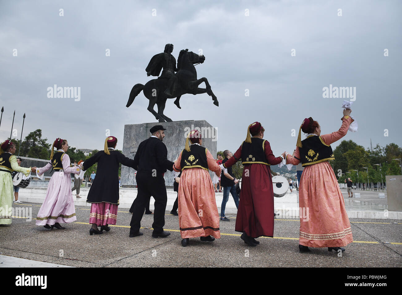 Thessalonique, Grèce. 30 juillet, 2018. Des gens habillés en costumes traditionnels de la danse en face de la statue d'Alexandre le Grand sur le front de mer de Thessalonique. Des centaines de personnes ont dansé au bord de l'eau de la partie nord de Thessalonique, un Grec Macédonien traditionnel danse appelée ''Mmacédonienne Syrto'', afin de protester contre l'Accord sur Prespa débat entre la Grèce et la Macédoine. Credit : Giannis Papanikos/ZUMA/Alamy Fil Live News Banque D'Images