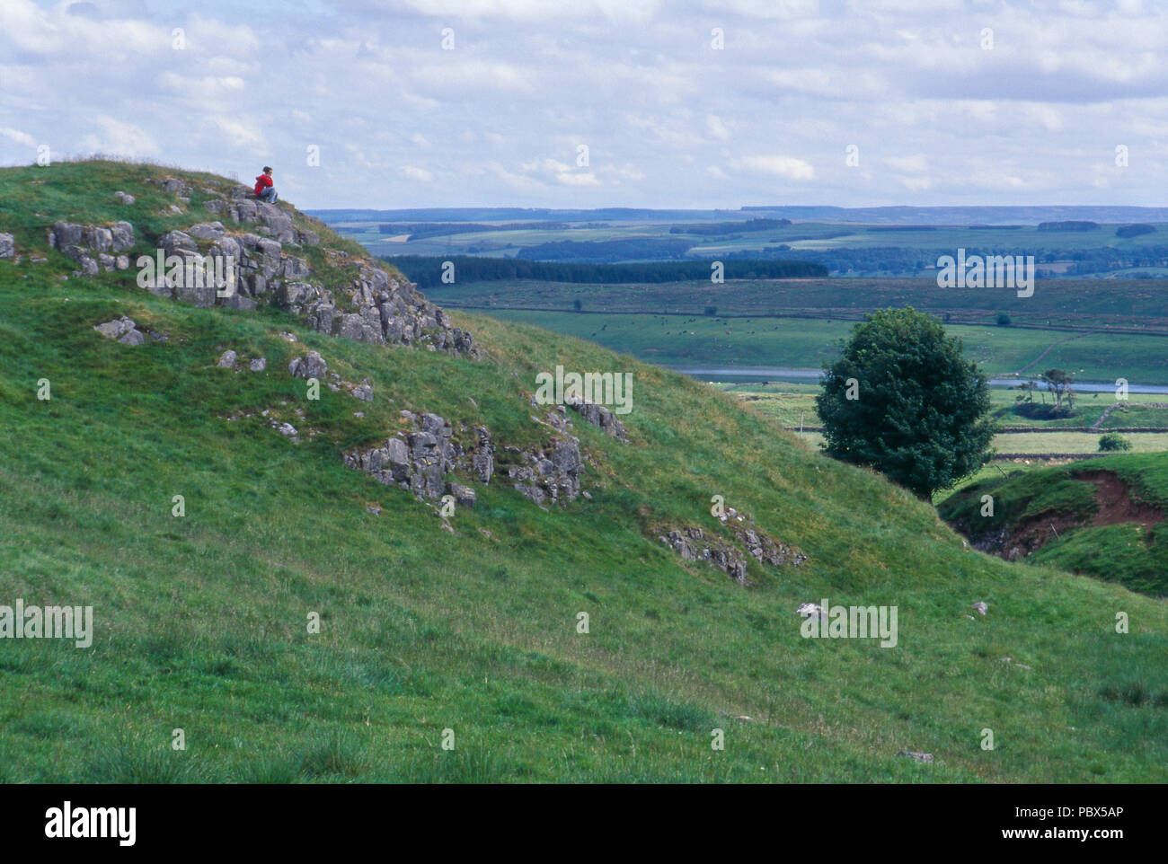 Girl randonneur sur un rocher surplombant les landes du Yorkshire, Angleterre. Photographie Banque D'Images