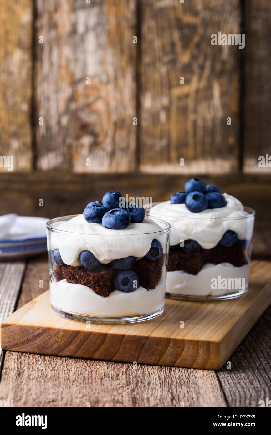 Gâteau au chocolat trifle myrtille en verre sur une table en bois rustique, de délicieux dessert d'été Banque D'Images