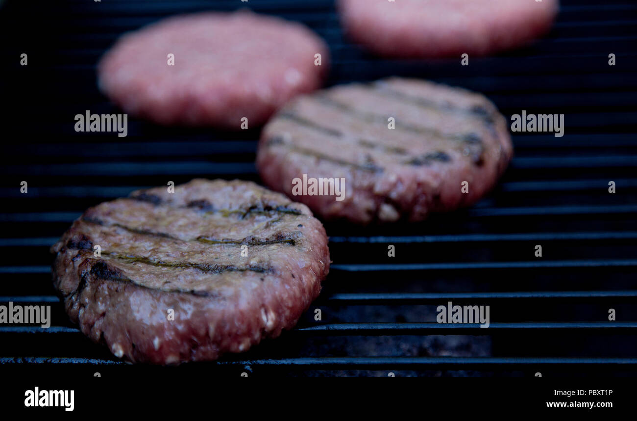 La cuisson sur barbecue beefburgers Banque D'Images